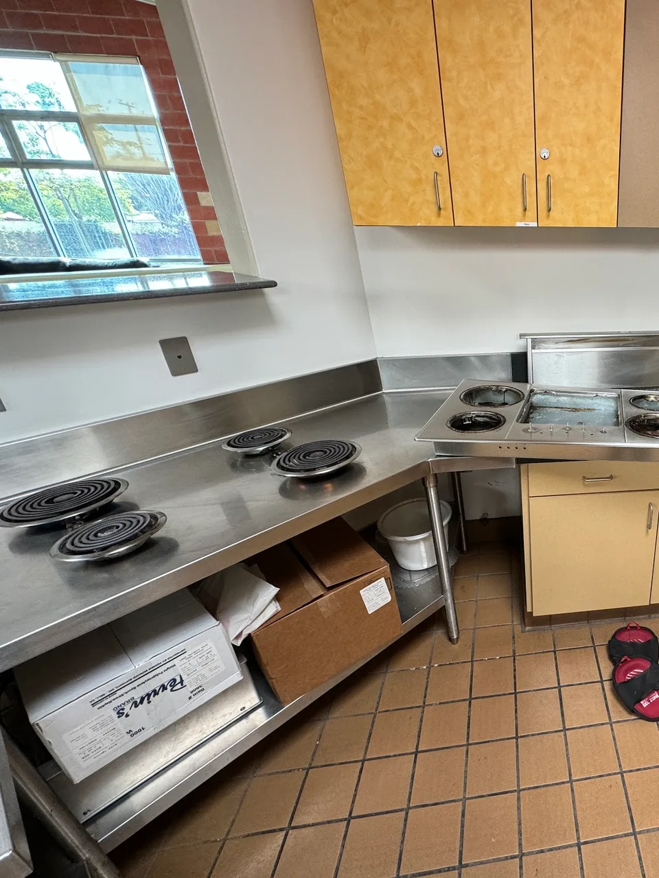 Four electric coil cooktop elements set into a stainless work counter