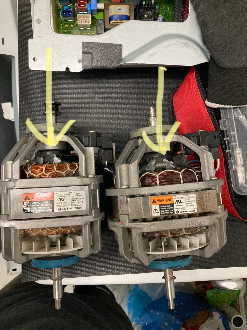 Two commercial washer drive motors side by side with replacement marks on their mounts