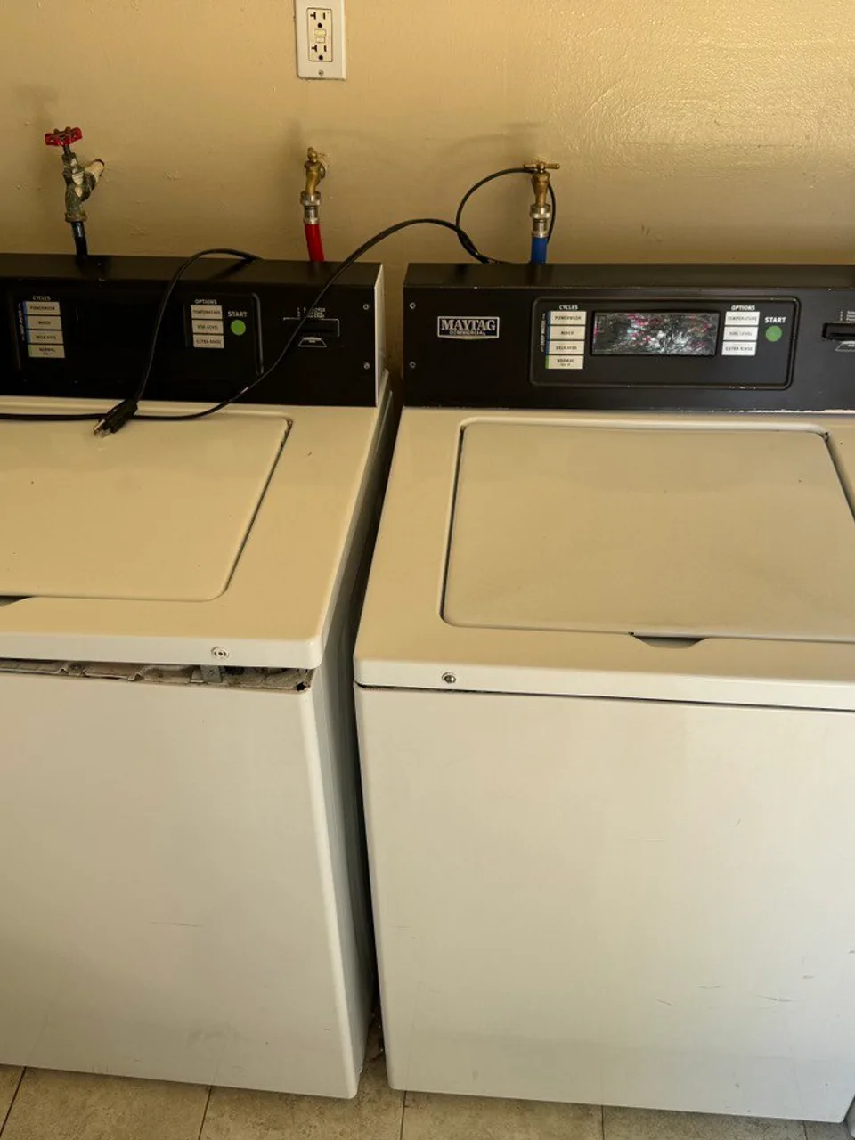 Two Maytag commercial washers with card payment readers built into their control panels