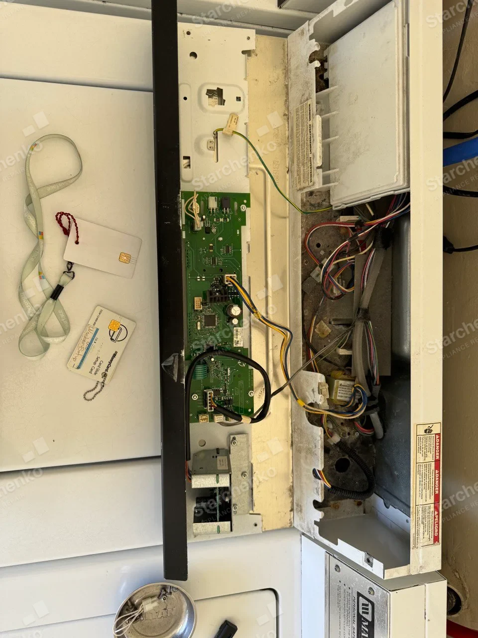 Maytag Commercial washer control panel opened to expose circuit boards, wiring and card keys