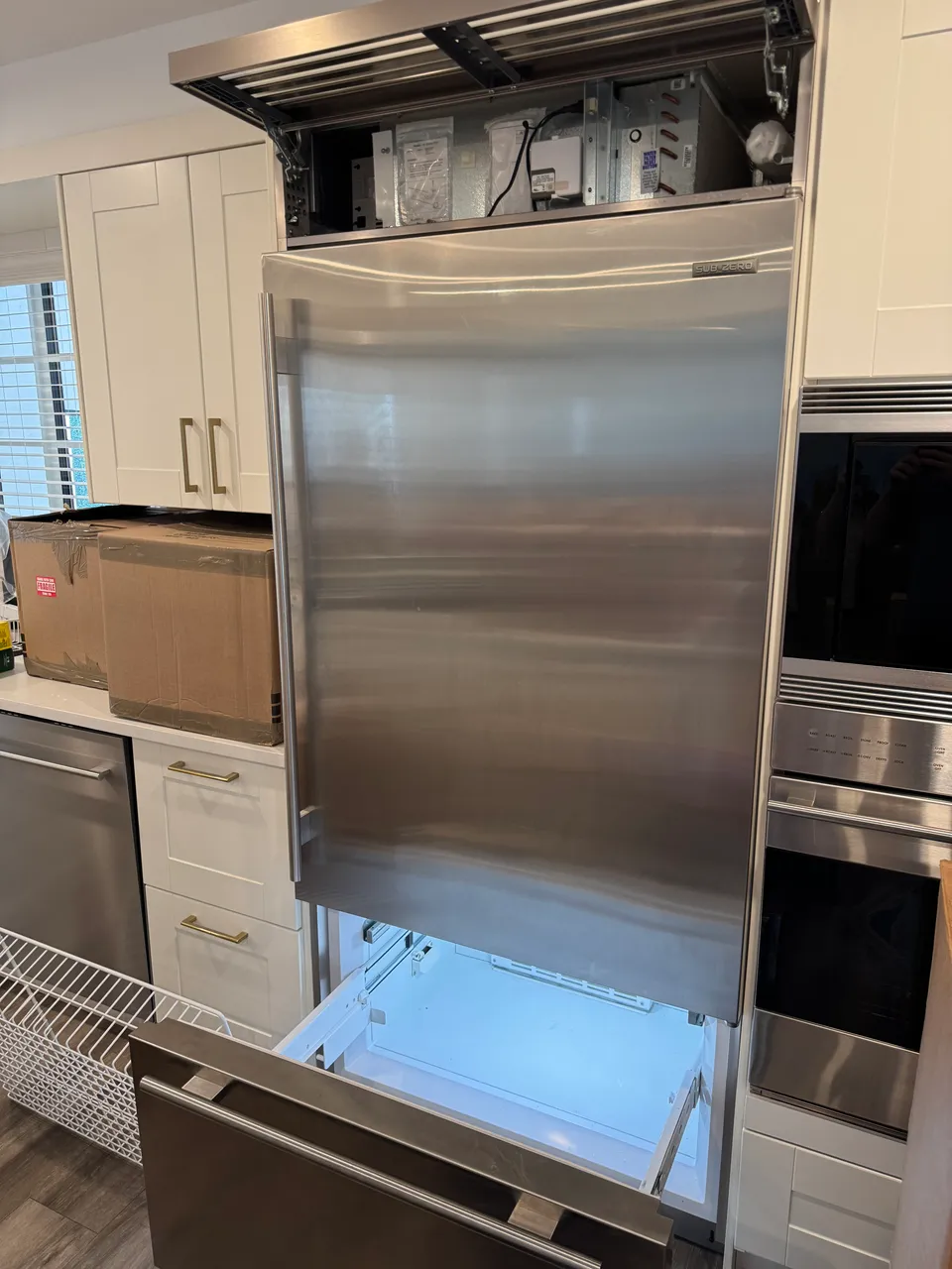 Sub-Zero built-in refrigerator with the top grille removed and the condenser compartment open