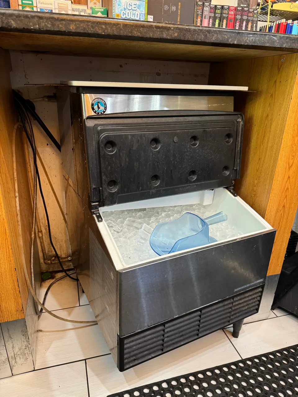 Commercial undercounter ice machine with the storage bin open and ice inside