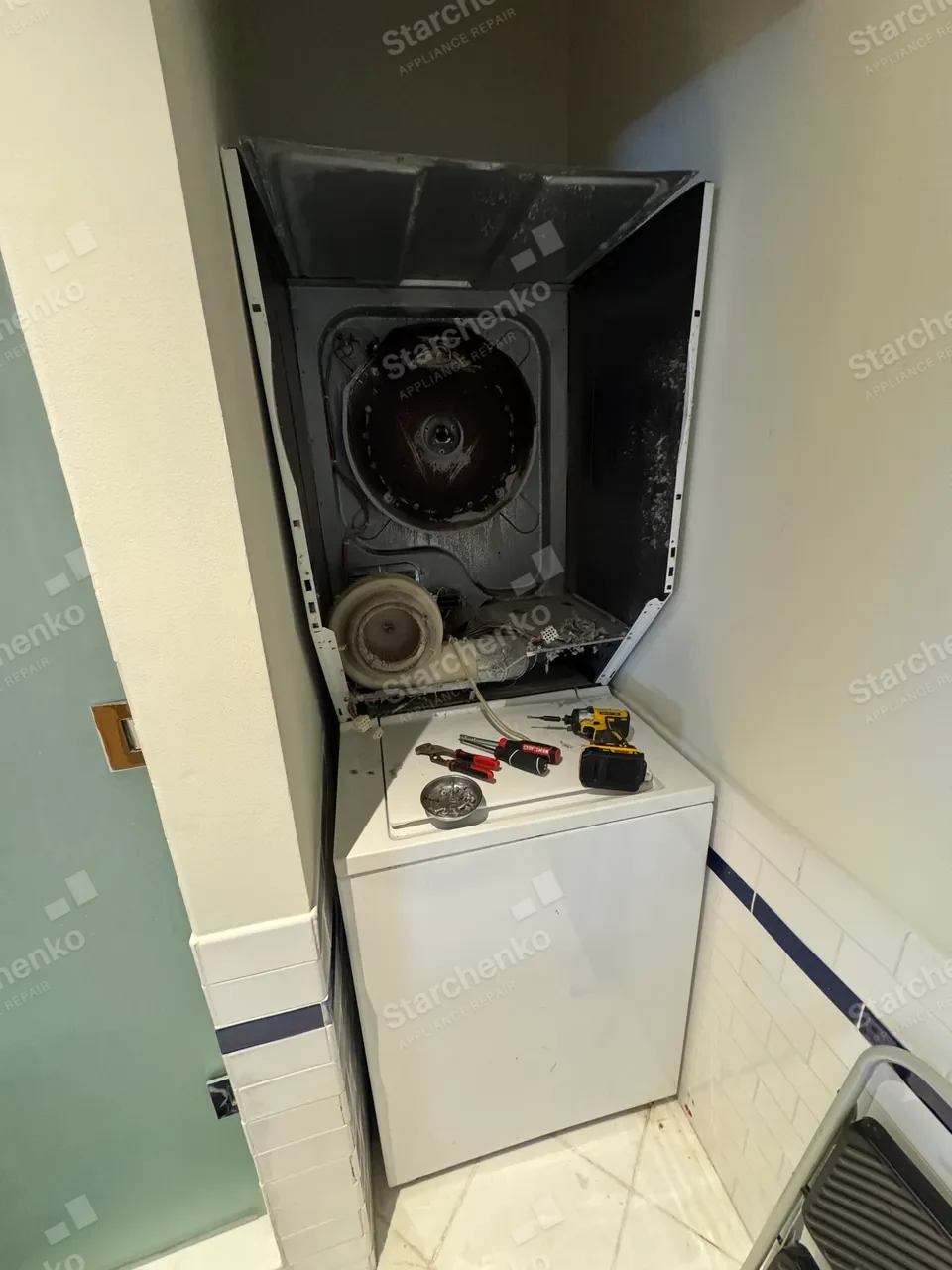 Frigidaire laundry center with the dryer front removed, drum, blower wheel and lint area exposed
