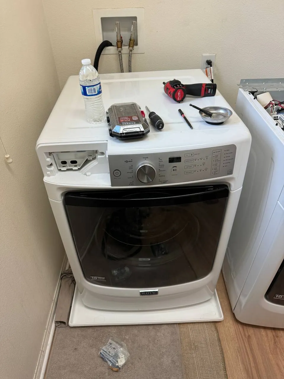 Maytag front-load washer with the detergent drawer out and repair tools on top