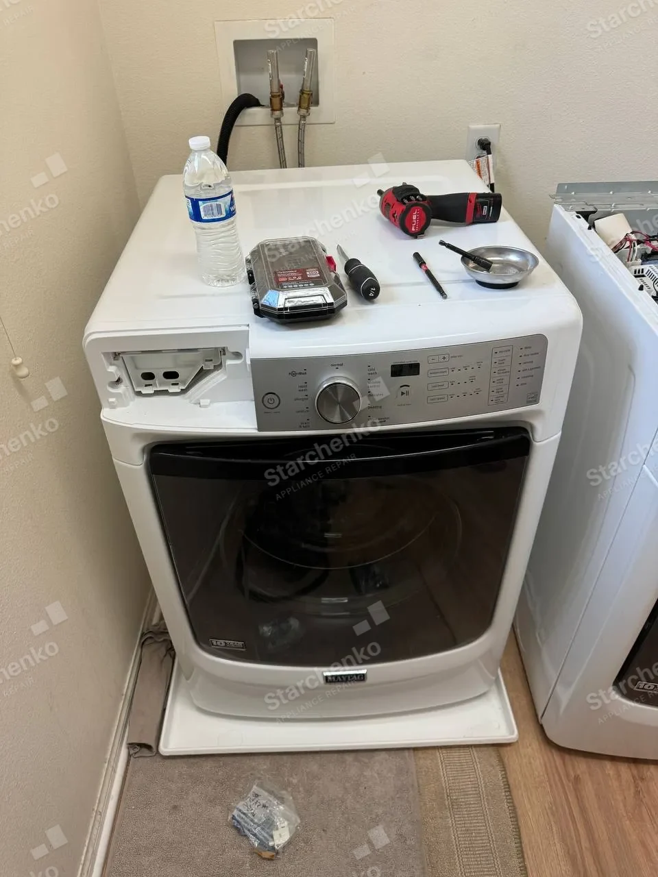 Maytag front-load washer with the detergent drawer out and repair tools on top