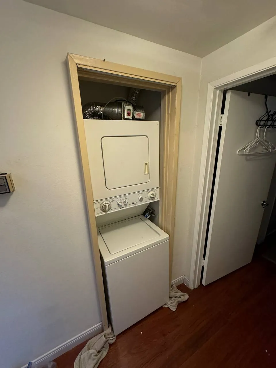 White Frigidaire stacked laundry center installed in a narrow closet