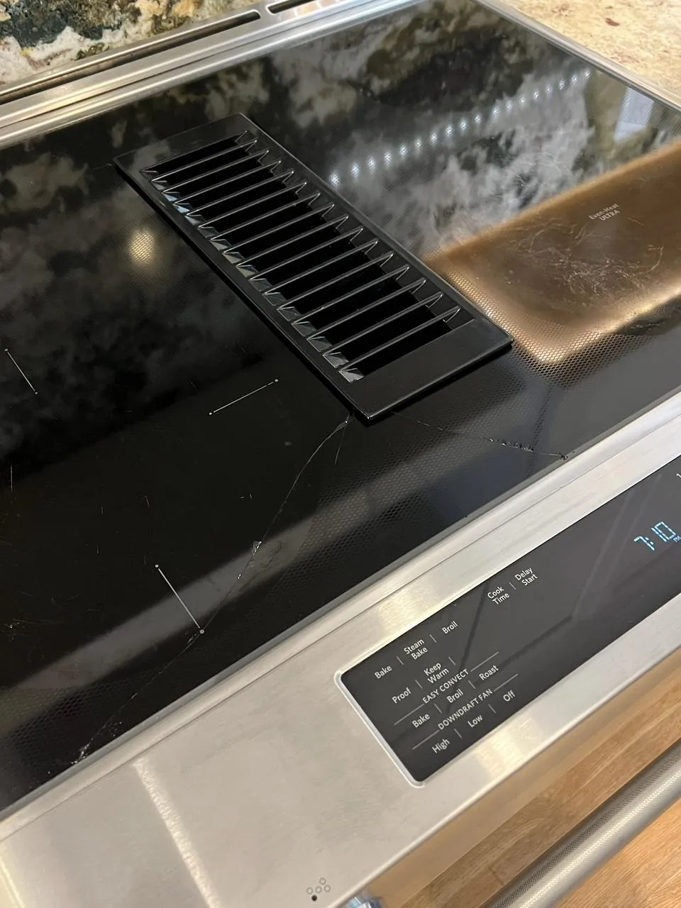Black glass KitchenAid cooktop with cracks radiating across the surface