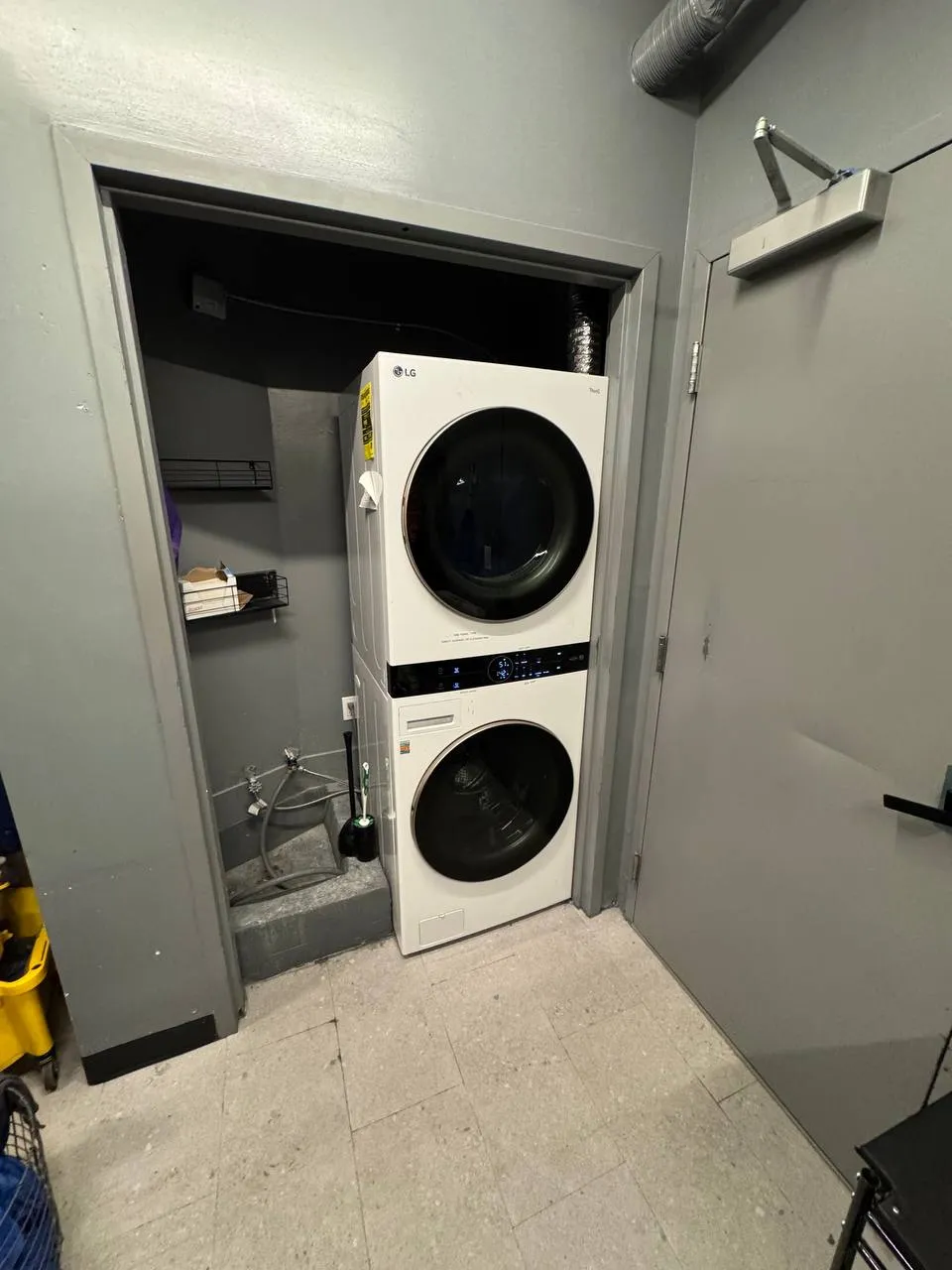 White LG WashTower standing in a gray utility room