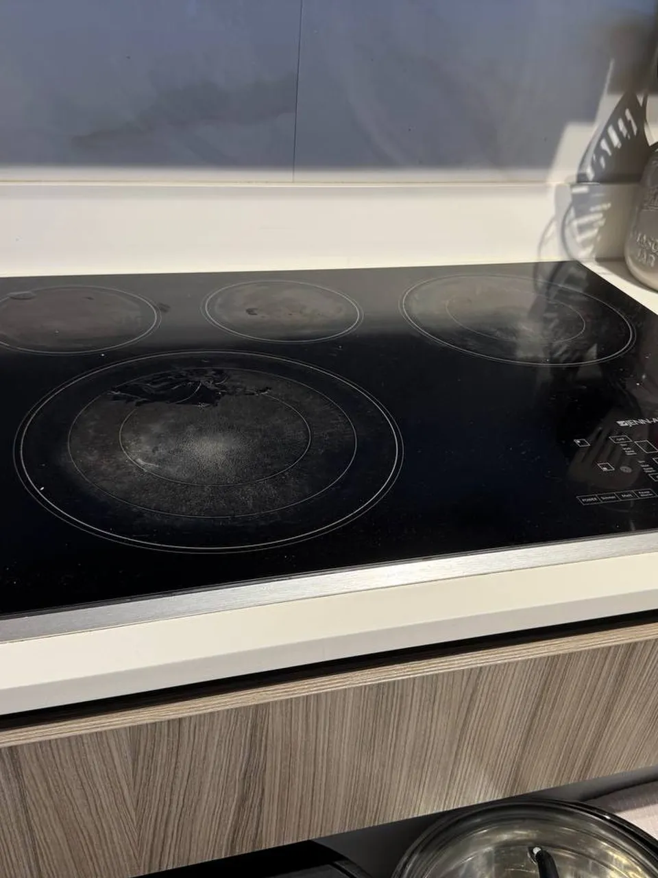 Four-burner Jenn-Air glass ceramic cooktop with touch controls on the right