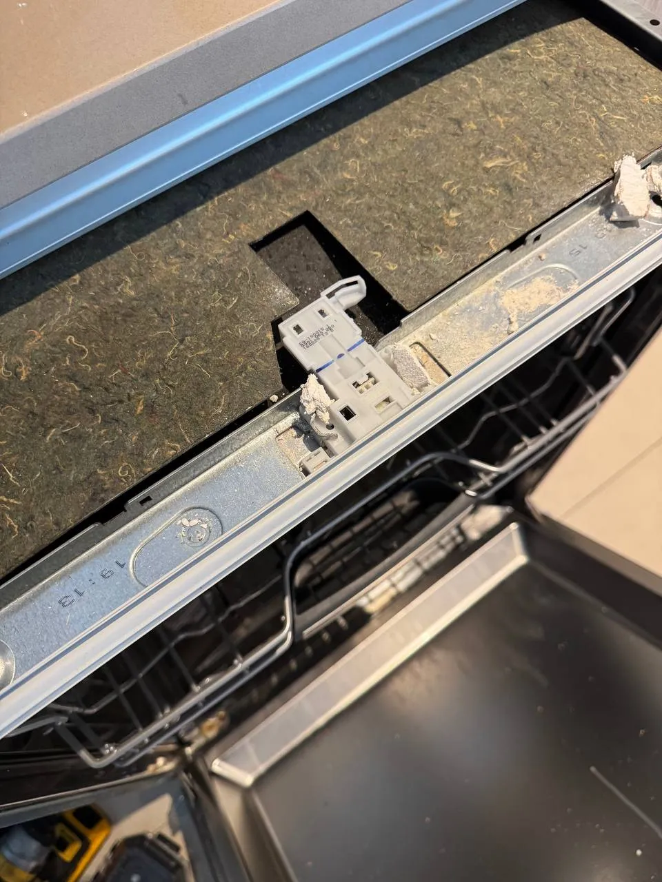 KitchenAid dishwasher door with the latch visible beneath the insulation