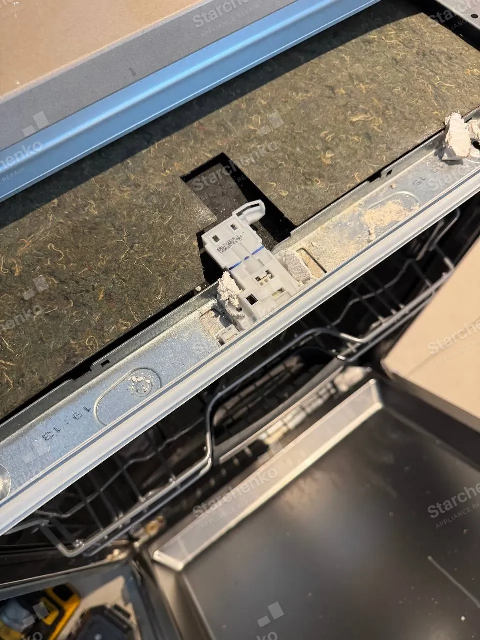 KitchenAid dishwasher door with the latch visible beneath the insulation