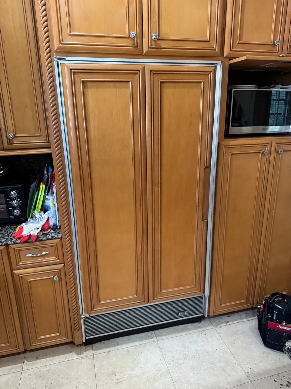 Panel-ready Sub-Zero refrigerator built into wood kitchen cabinetry