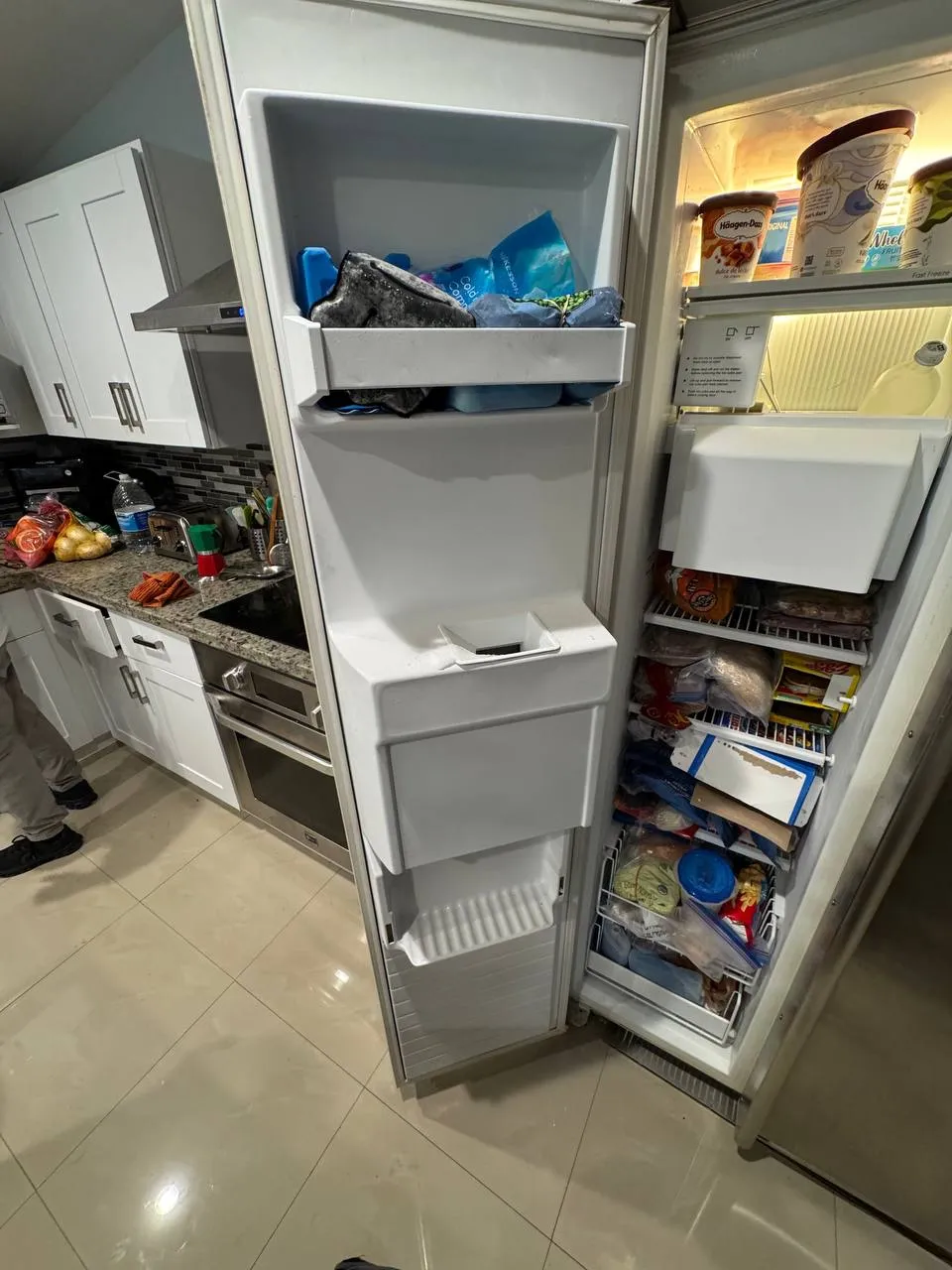 Open Whirlpool side-by-side refrigerator with food in the freezer and refrigerator sections