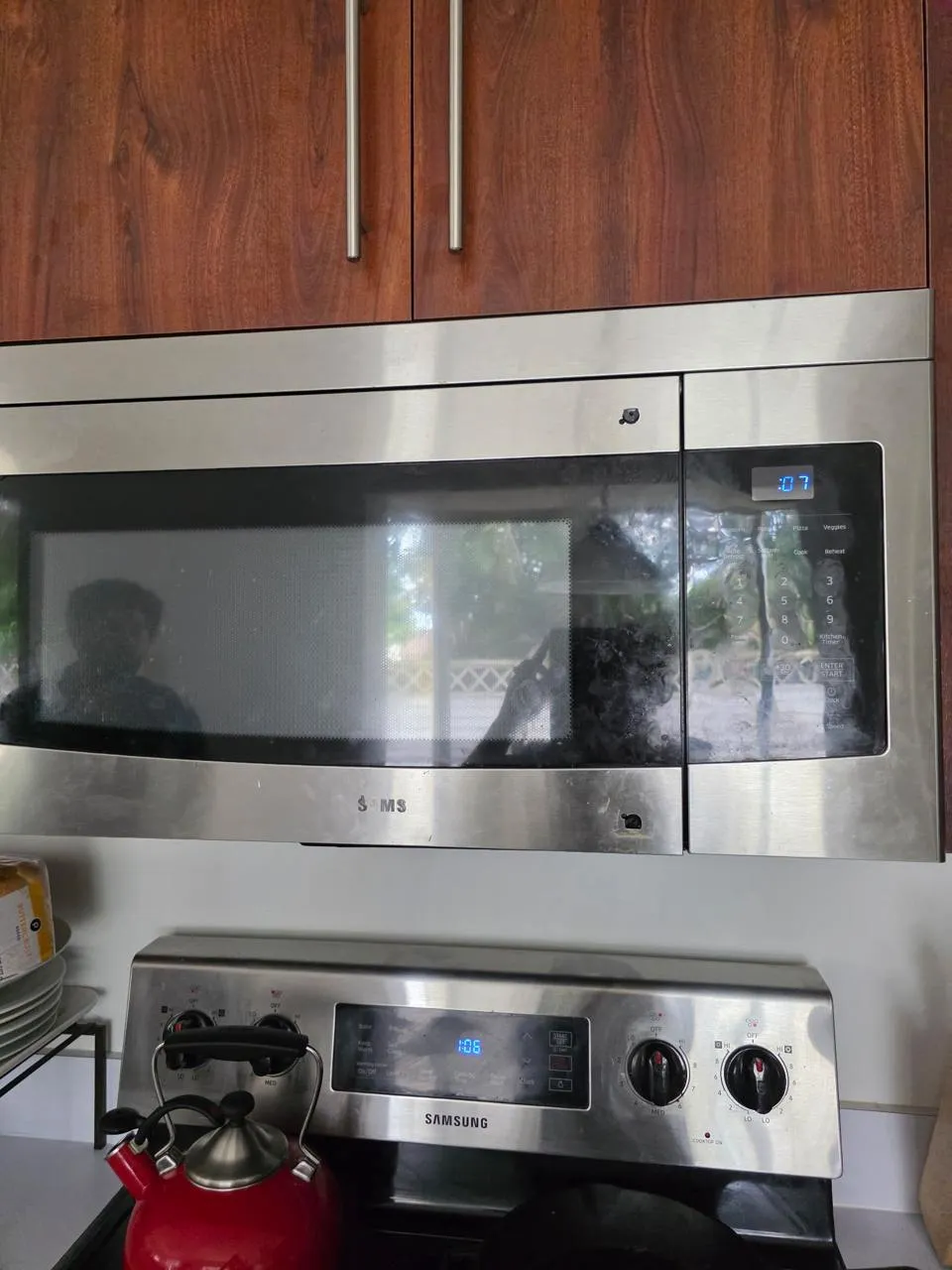 Samsung over-the-range microwave mounted above a range with its door visible