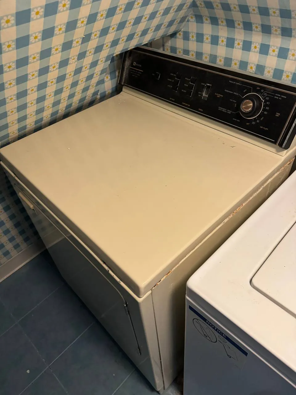 Vintage Maytag dryer with a black control panel beside a top-load washer