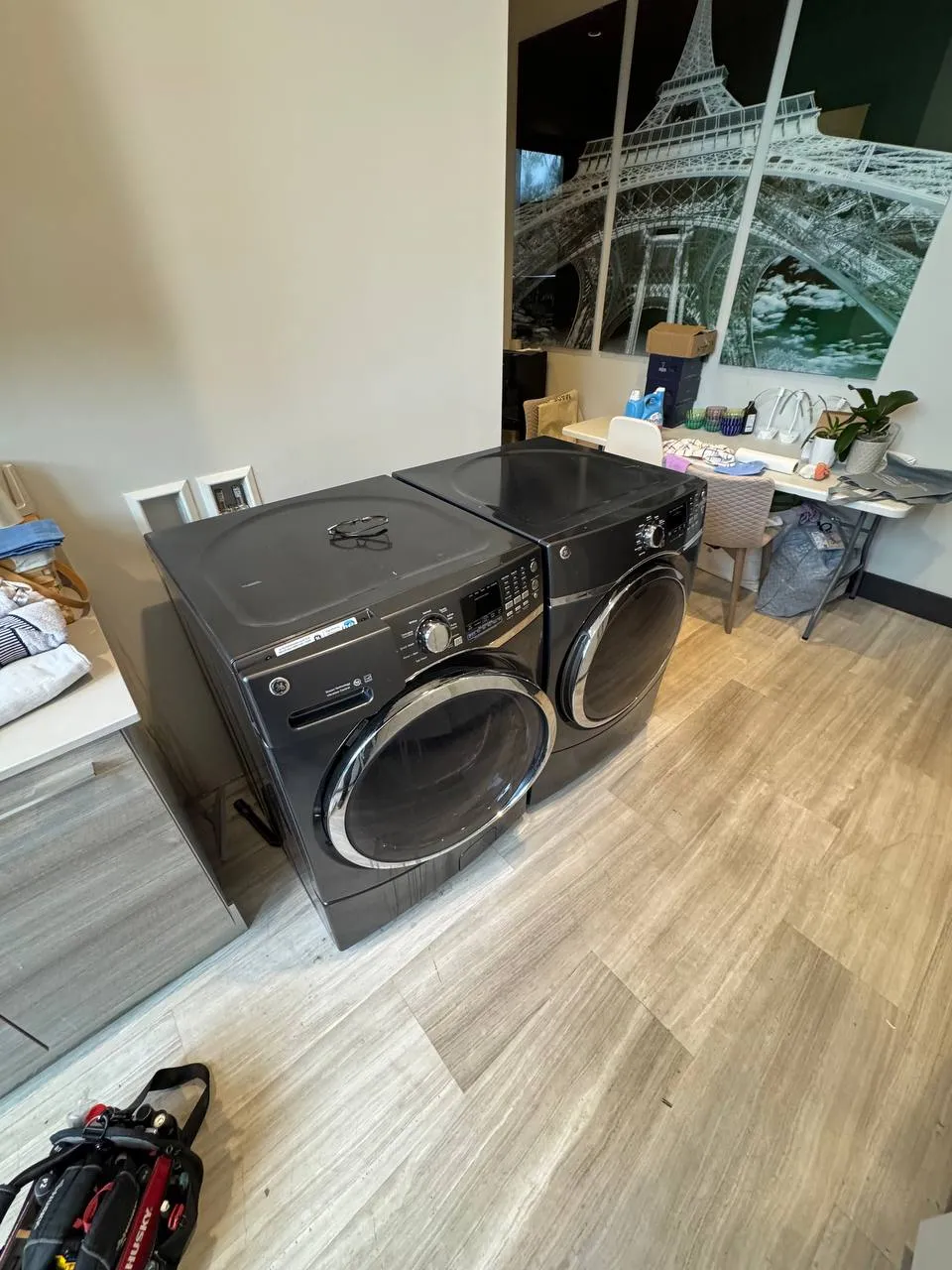 Dark gray GE washer and dryer standing side by side in a laundry room