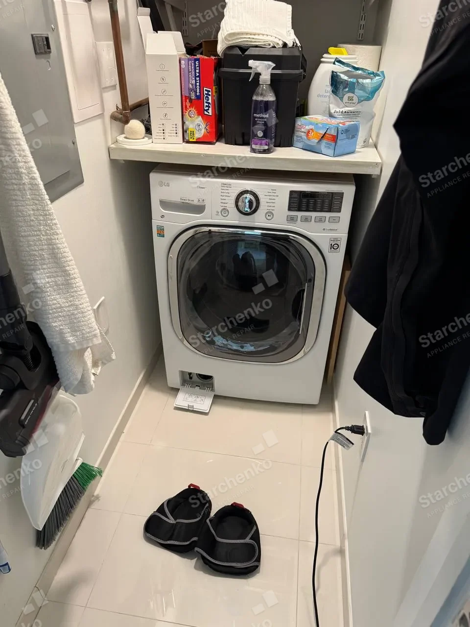 White LG front-load washer beneath a shelf of laundry supplies