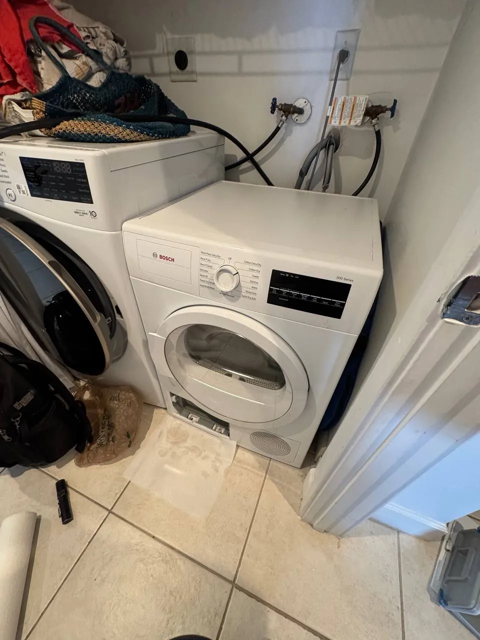 Bosch dryer beside a washer with its lower service hatch open