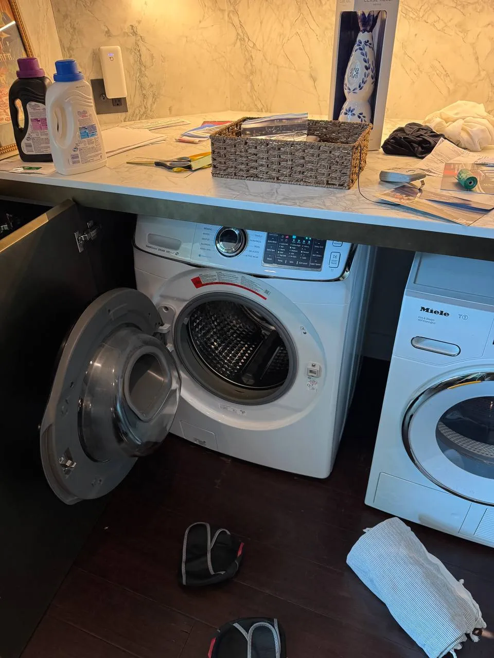 GE front-load washer under a counter with its door open