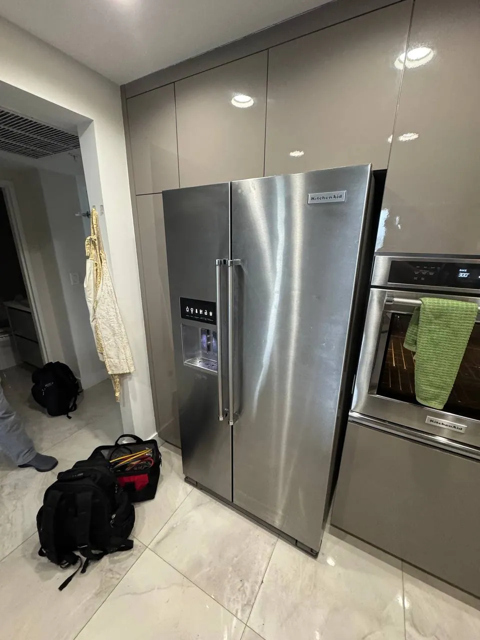Stainless KitchenAid side-by-side refrigerator beside a wall oven