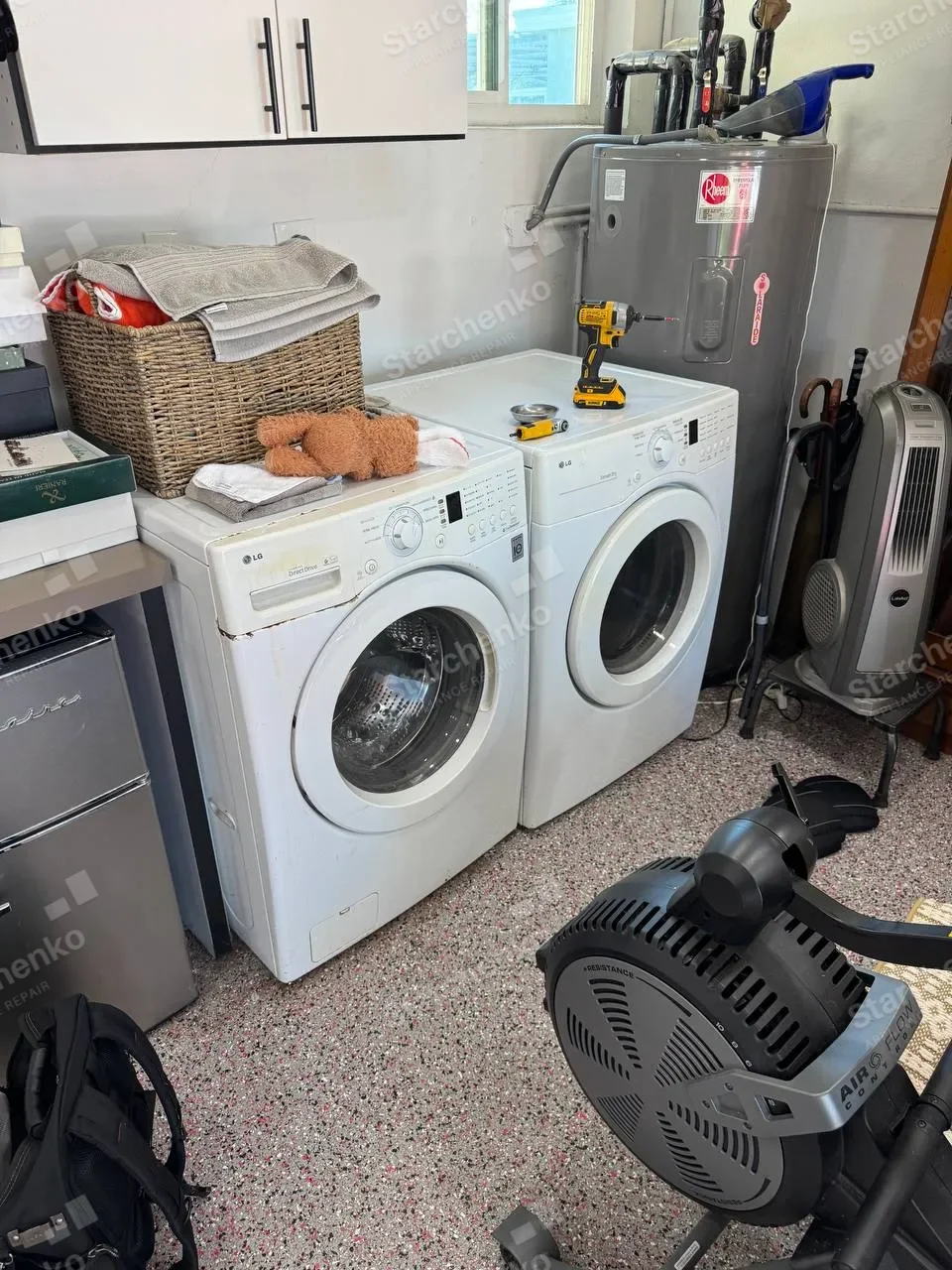 White LG washer and dryer pair with repair tools resting on the dryer
