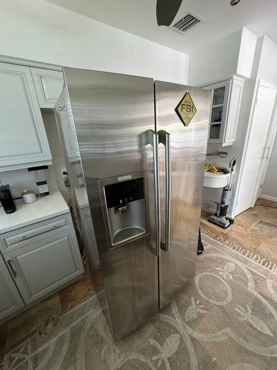 Stainless Electrolux side-by-side refrigerator with a water and ice dispenser in a bright kitchen