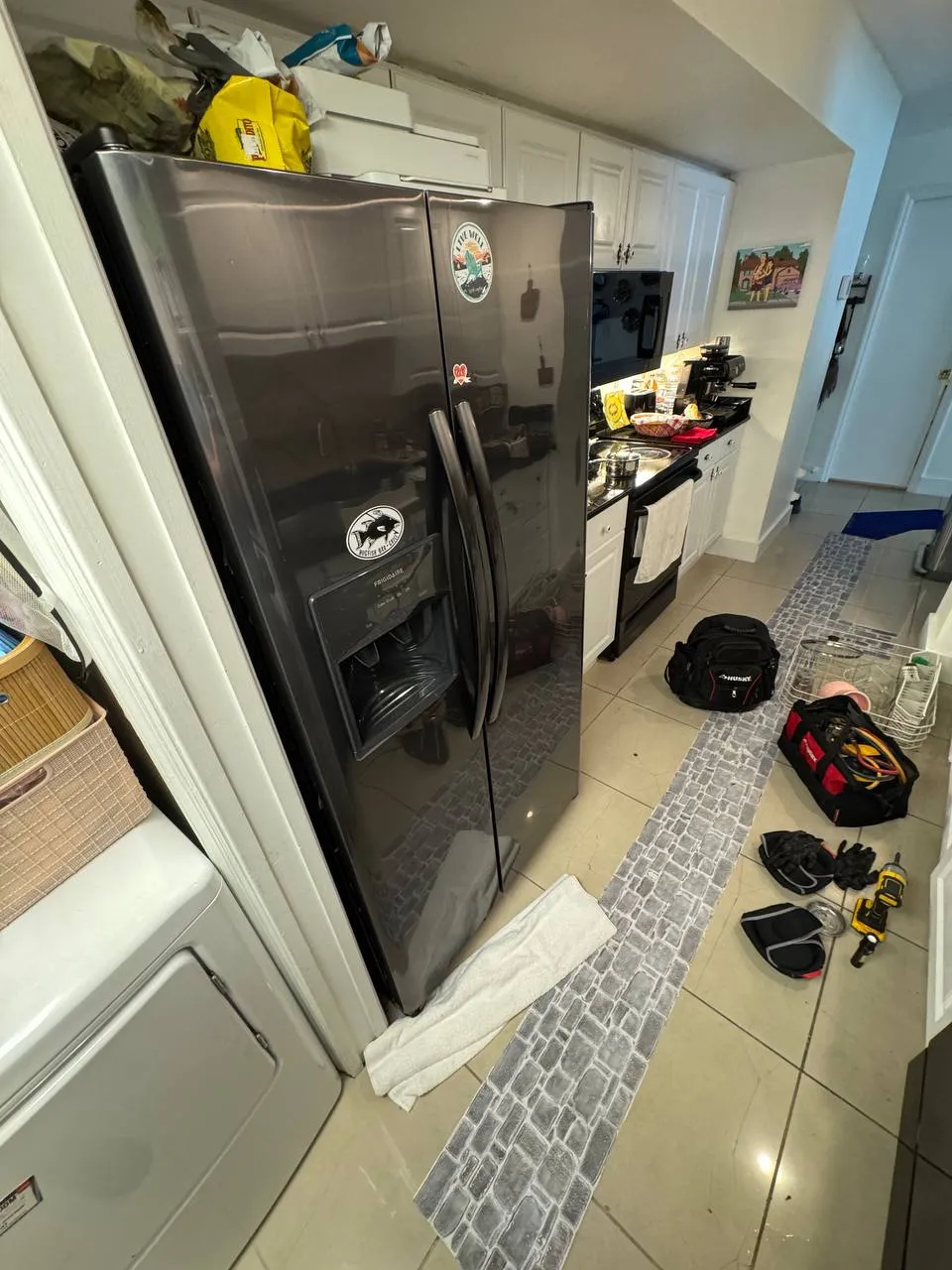 Black Frigidaire side-by-side refrigerator in a white kitchen