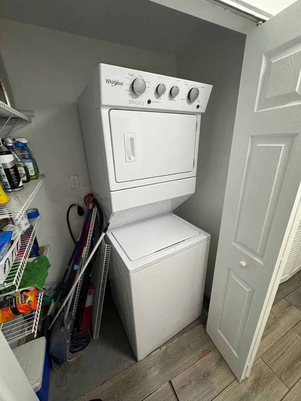 White Whirlpool stacked laundry center in a utility closet