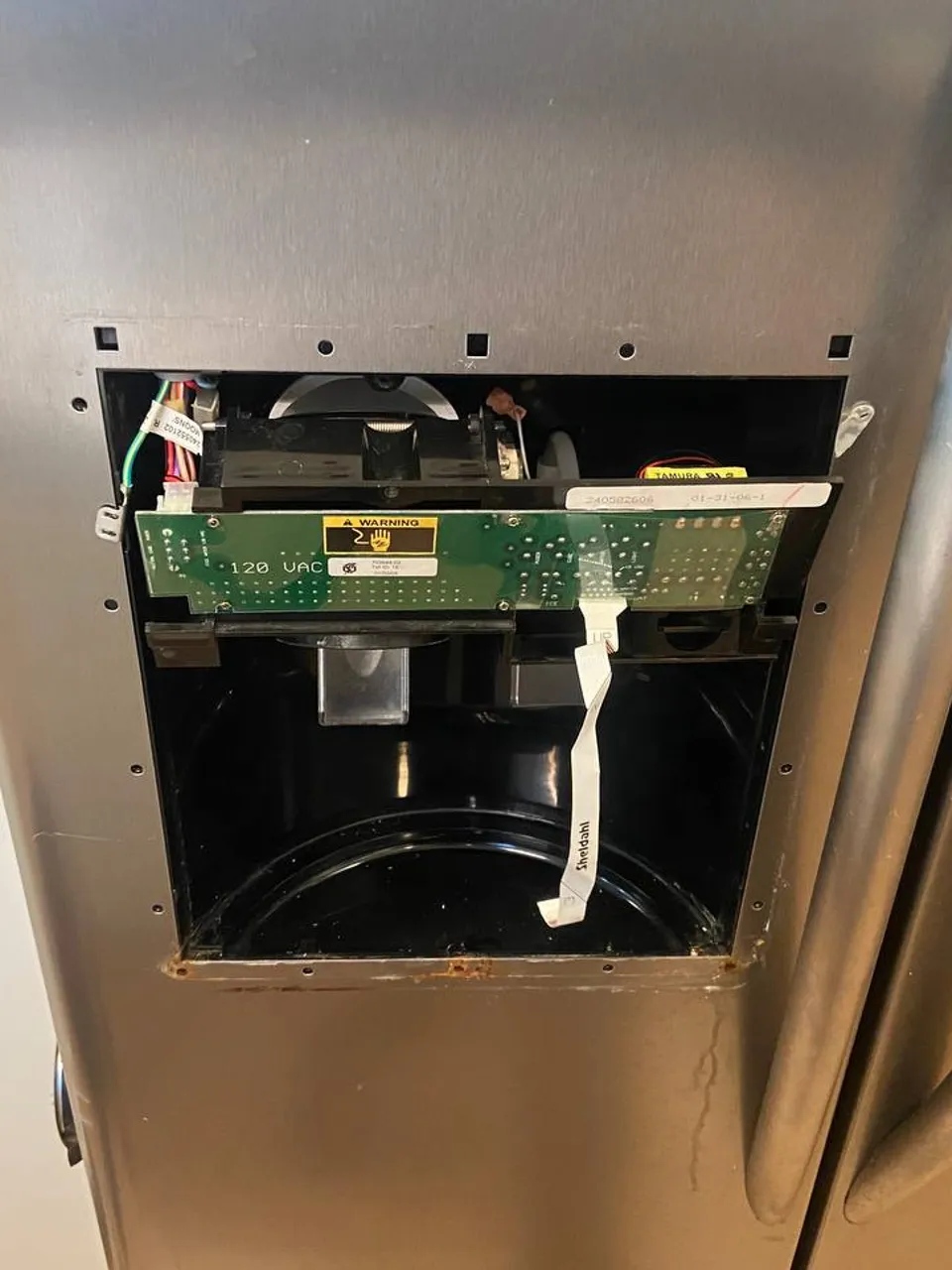 Electrolux refrigerator with its dispenser control removed and wiring exposed
