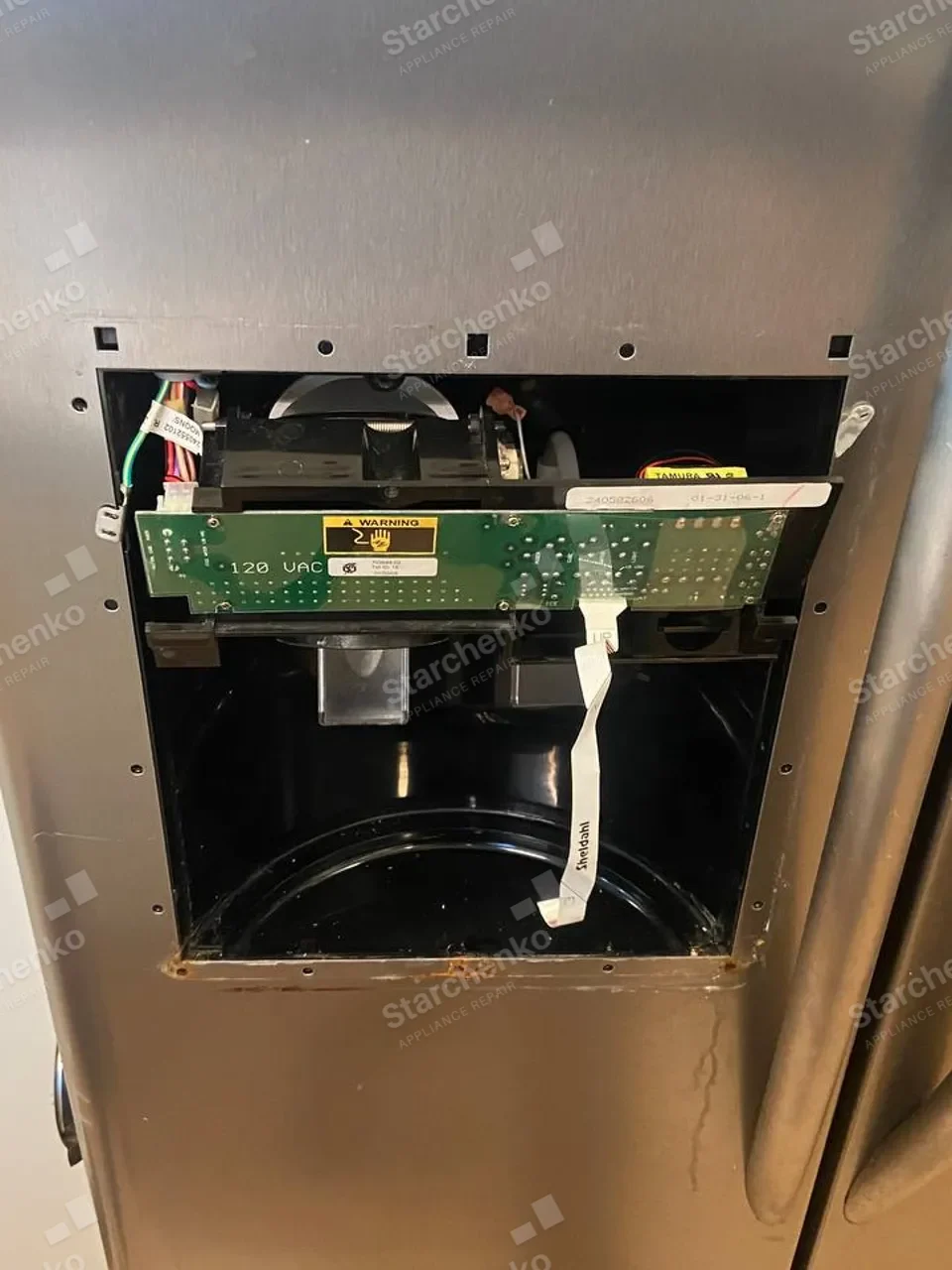 Electrolux refrigerator with its dispenser control removed and wiring exposed