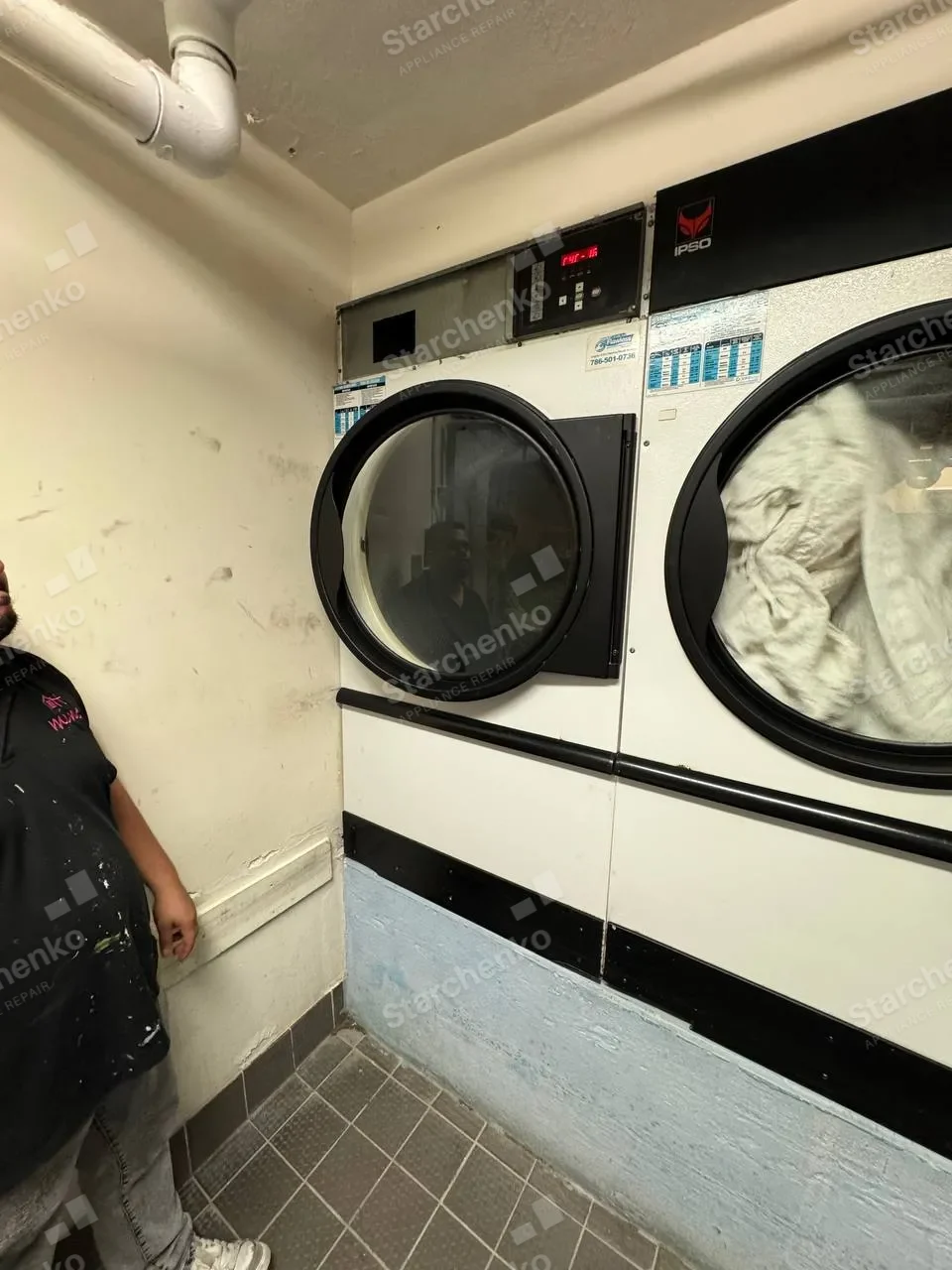 IPSO commercial dryer with its lower service panel open during a blower motor replacement