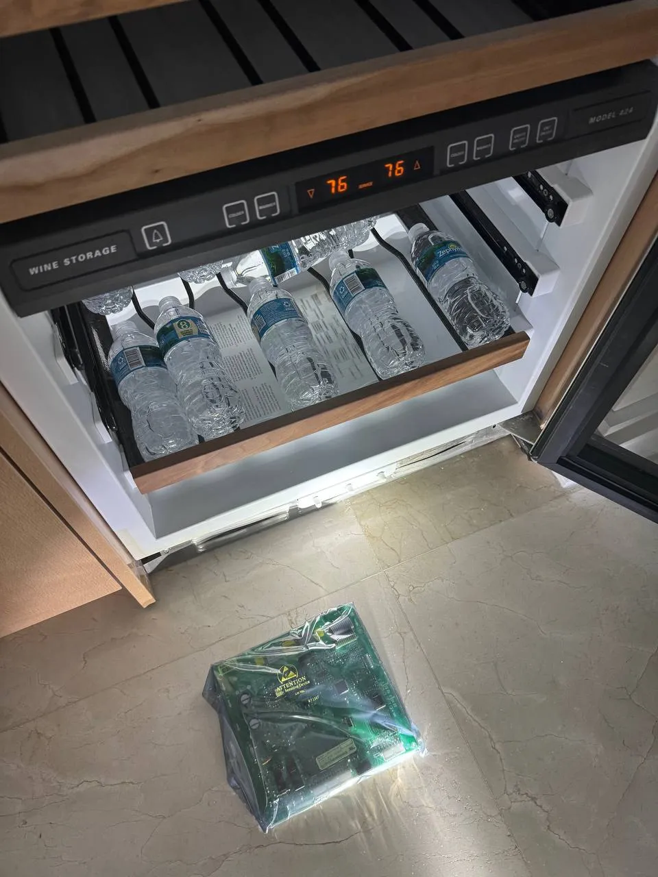 Sub-Zero wine storage drawer pulled open with the replacement control board on the floor