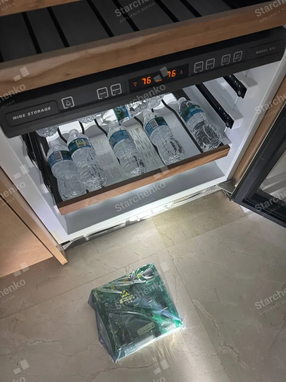 Sub-Zero wine storage drawer pulled open with the replacement control board on the floor