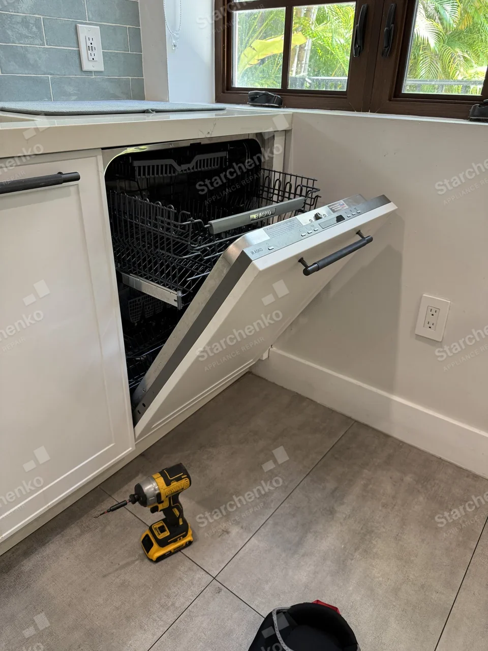 Panel-ready Asko dishwasher with the door open in a home kitchen