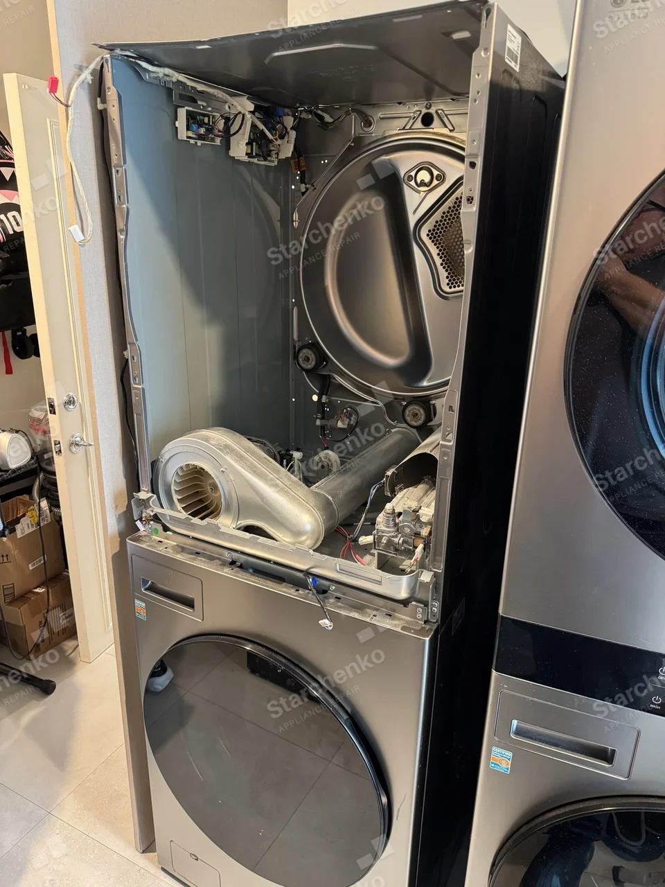 LG WashTower with the dryer cabinet opened up to expose the drum, blower housing and gas valve