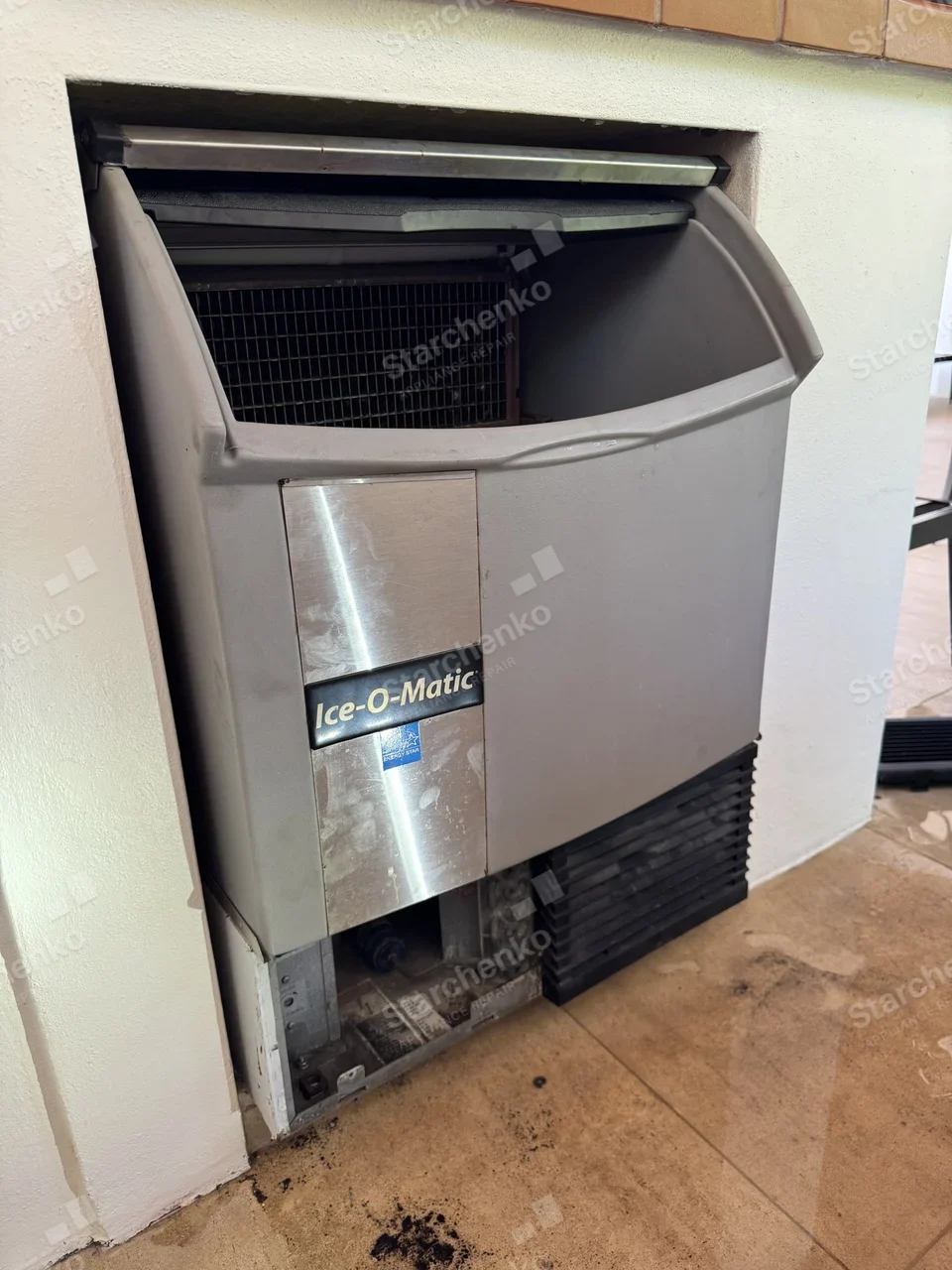 Built-in Ice-O-Matic ice machine at an outdoor bar with the lower grille removed
