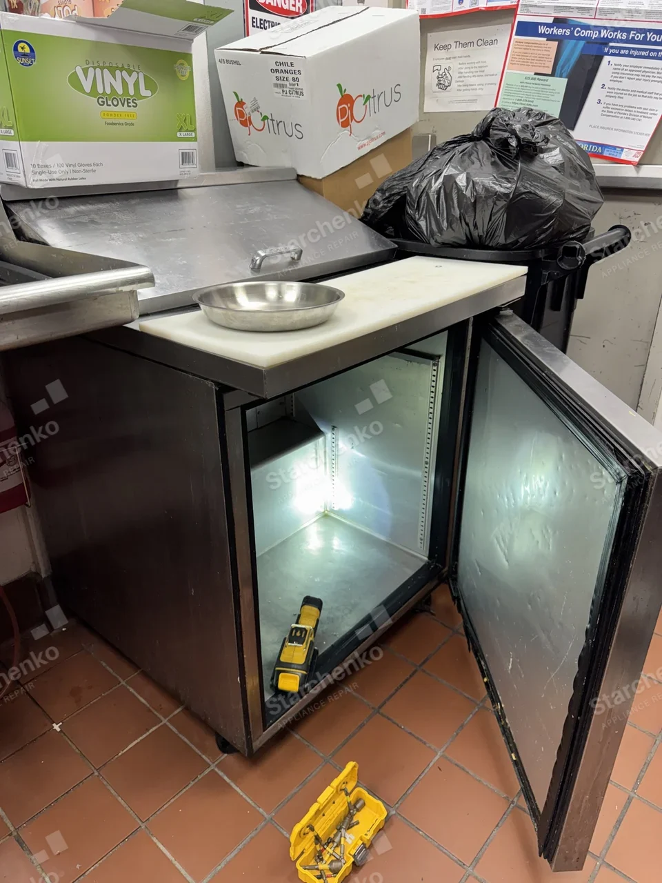 Arctic Air refrigerated sandwich prep table in a restaurant kitchen with the cabinet door open