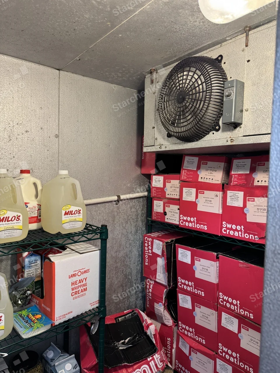 Evaporator unit with a fan guard inside a stocked walk-in cooler