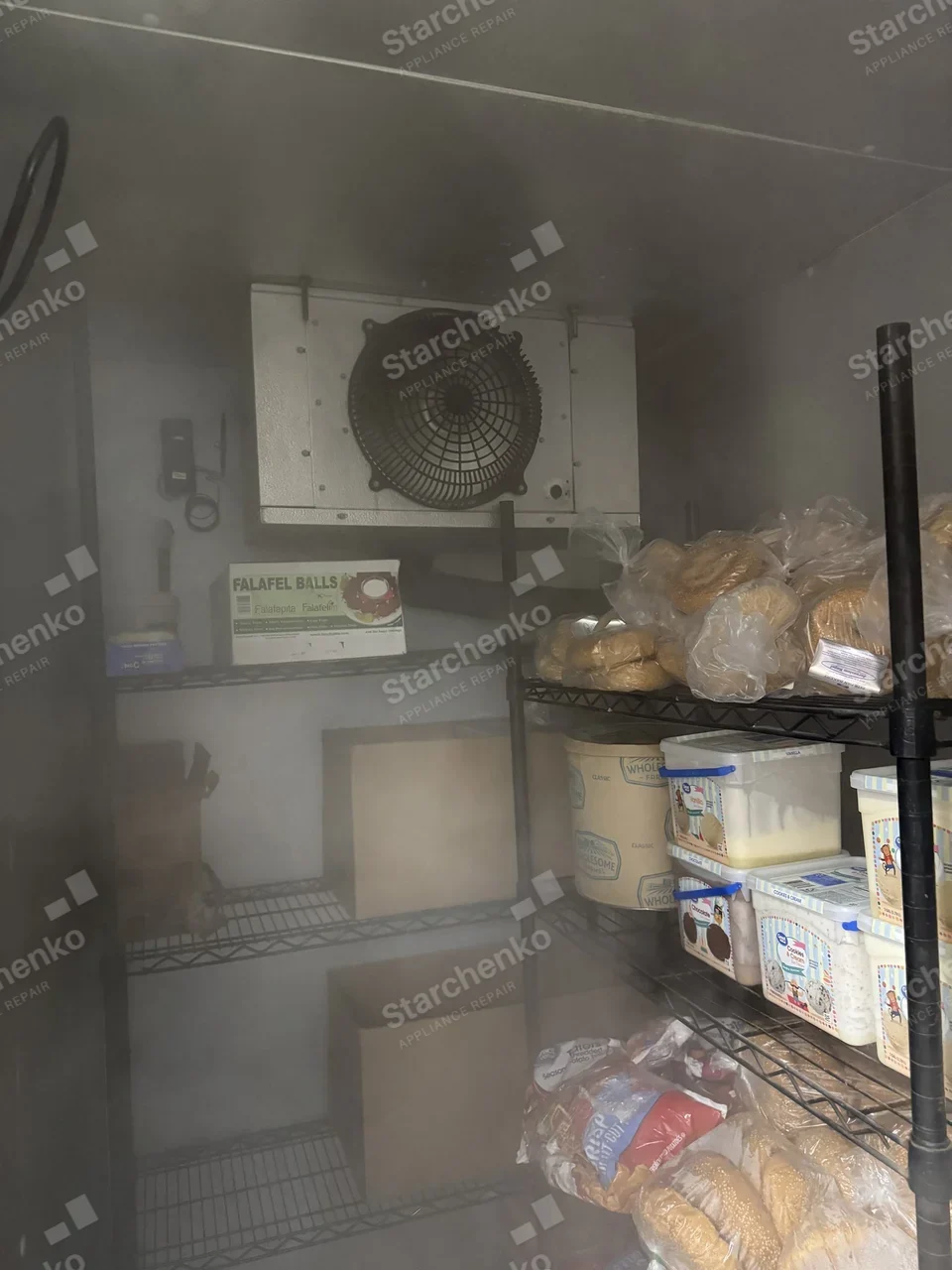 Evaporator fan inside a walk-in freezer with fog around the frozen stock