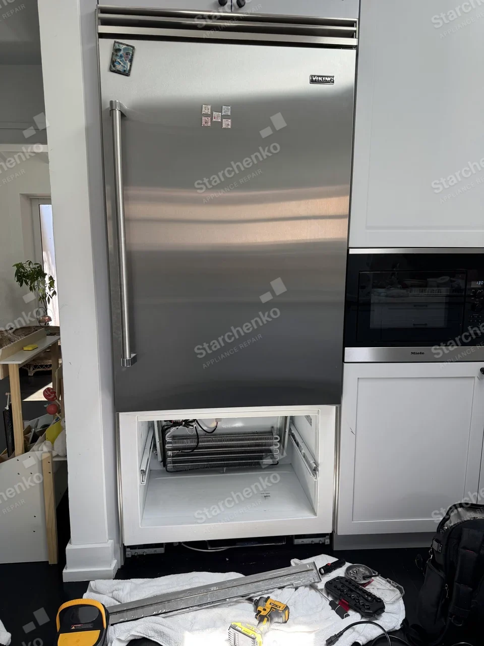 Viking built-in bottom-freezer refrigerator with the freezer drawer removed and the evaporator coils exposed