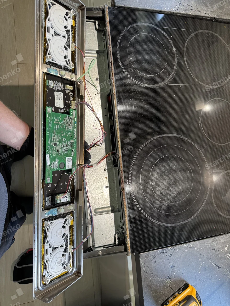 GE Café electric range with the control panel opened up to expose the boards and wiring