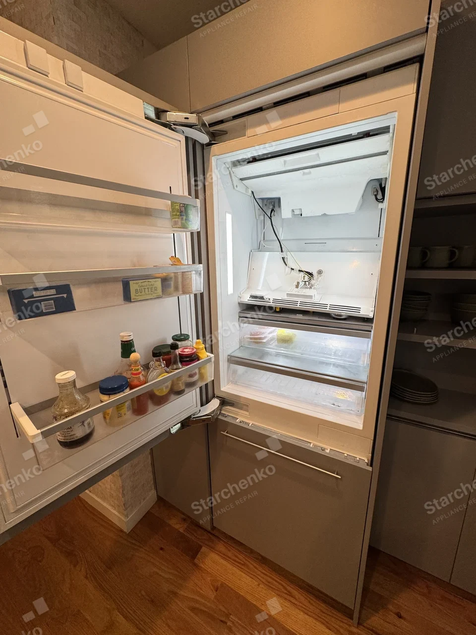 Panel-ready Bosch built-in refrigerator with the ice maker cover removed and its wiring exposed