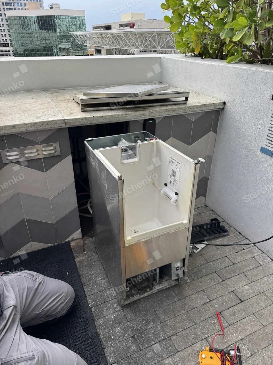 Hoshizaki undercounter ice maker pulled out from a rooftop bar counter with its top panel removed