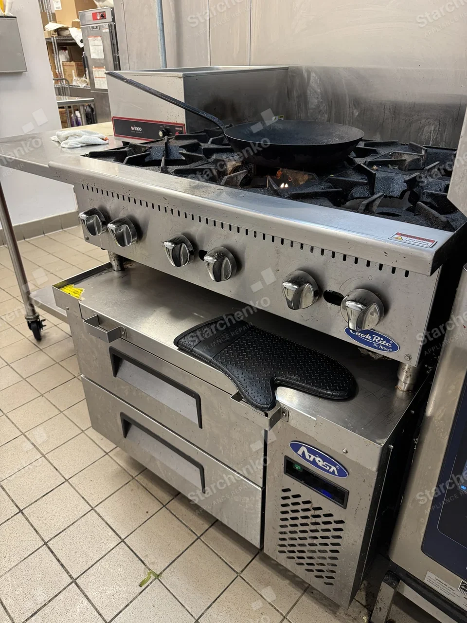 Atosa refrigerated chef base under a gas hot plate on a restaurant cook line
