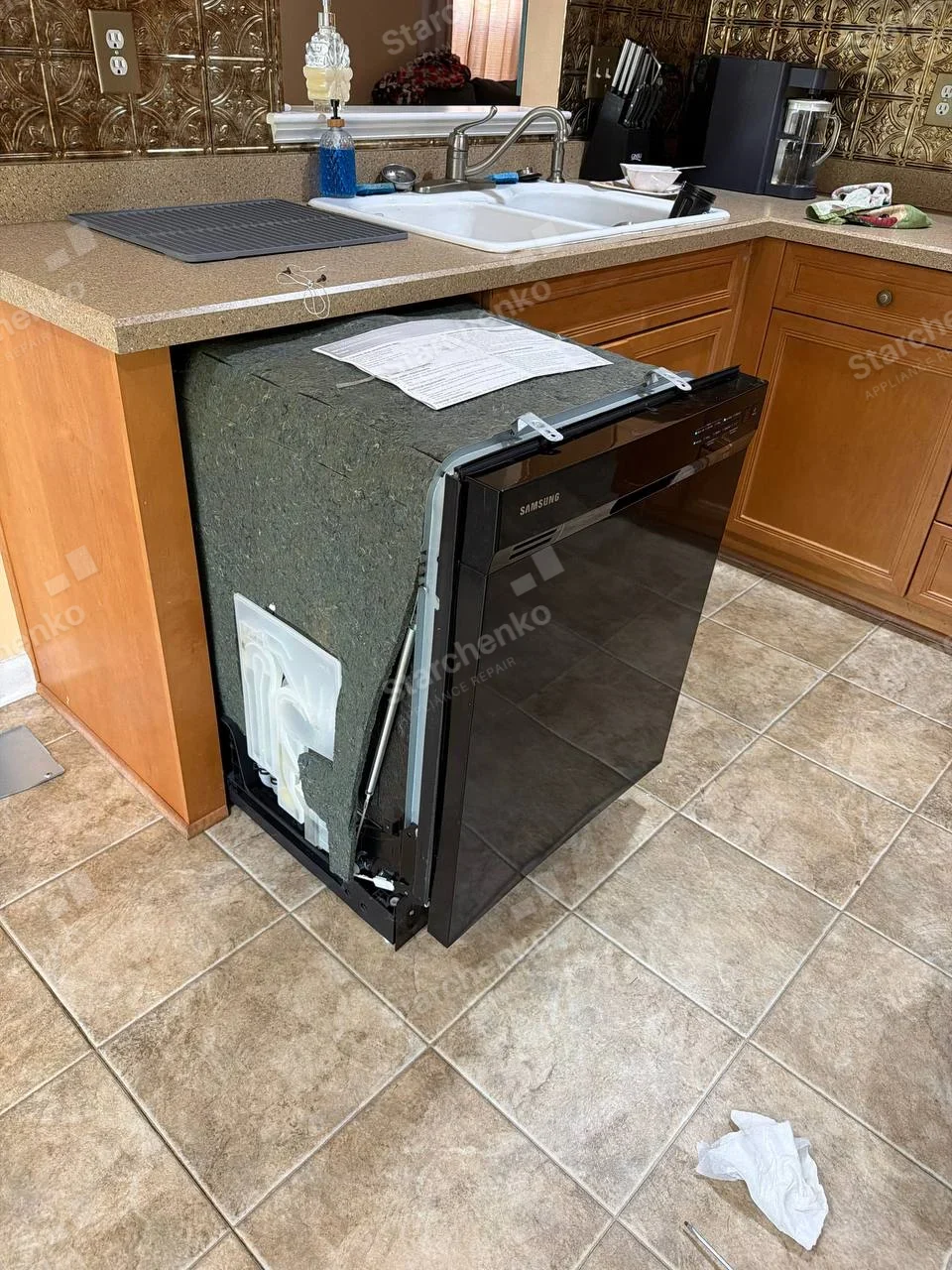 SAMSUNG wordmark on the front upper-left black fascia of a partially pulled-out dishwasher.