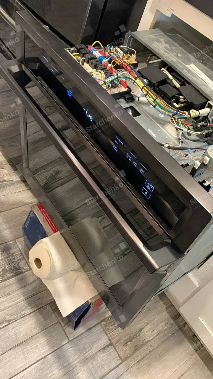 Whirlpool repair: Wall oven pulled out with upper control cover removed, displaying circuit boards, relays and wiring.