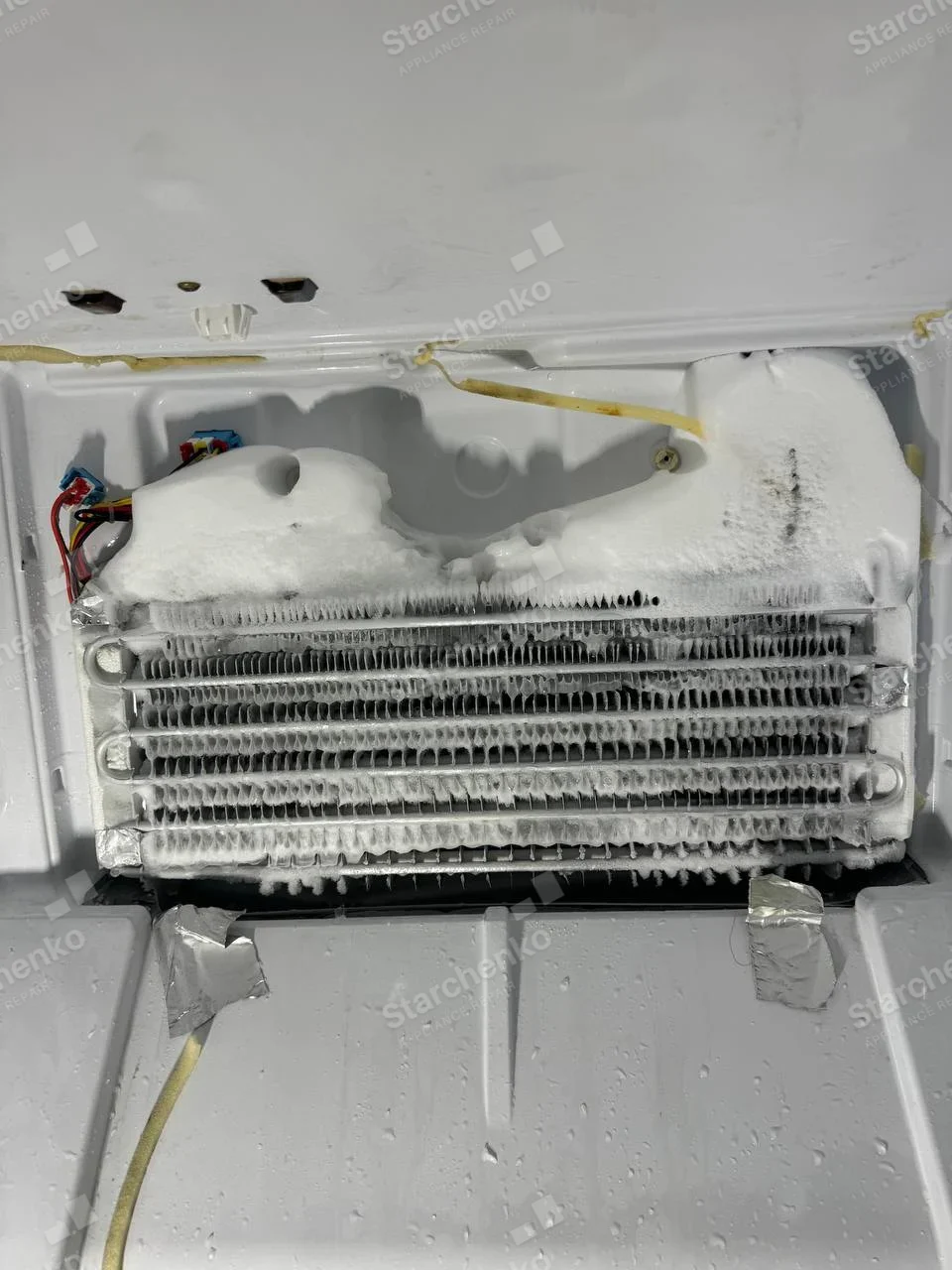 LG repair: Exposed horizontal freezer evaporator coil covered in frost with ice at top corners.