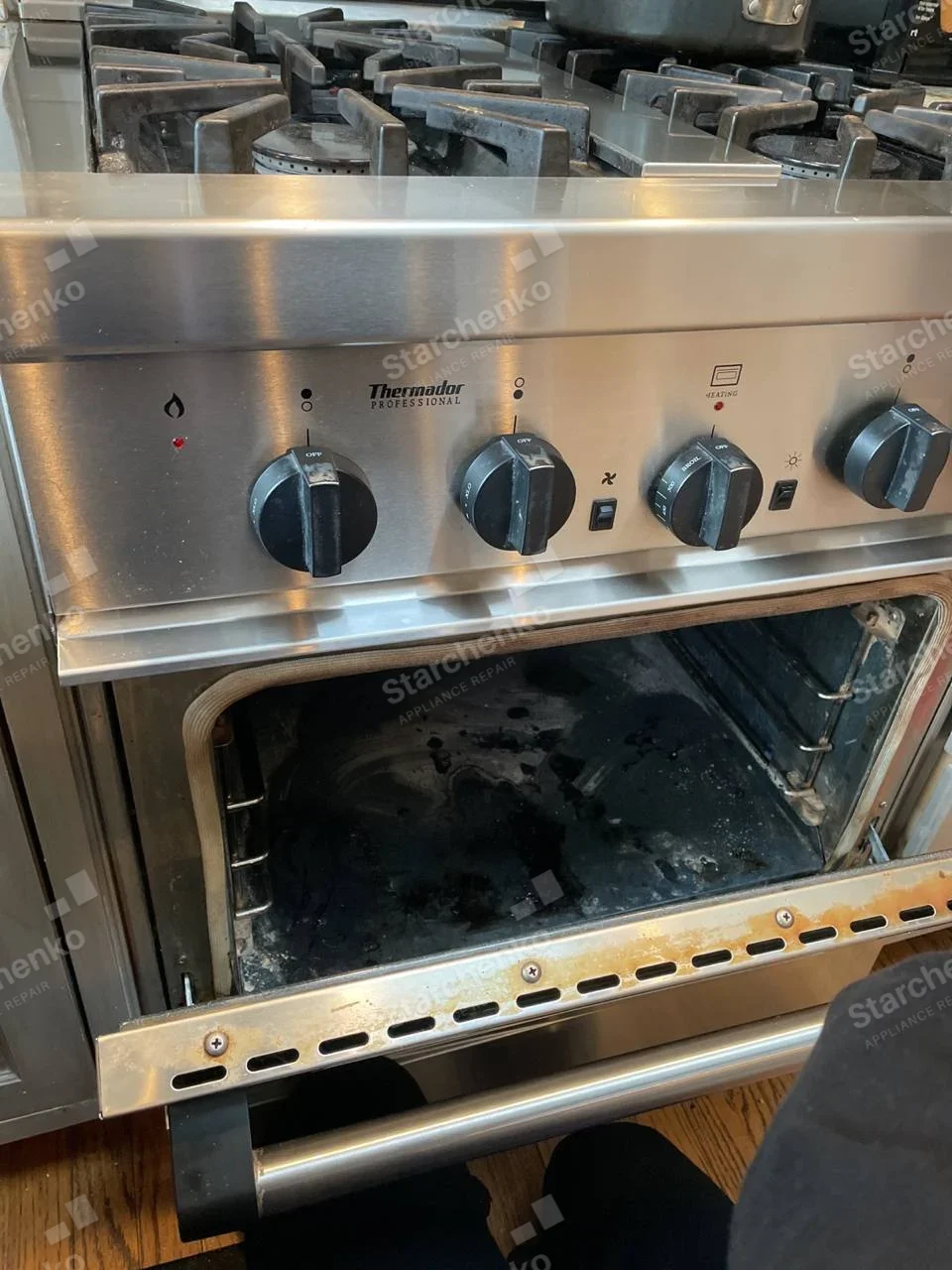 Thermador Professional range front controls and open oven cavity beneath gas cooktop.