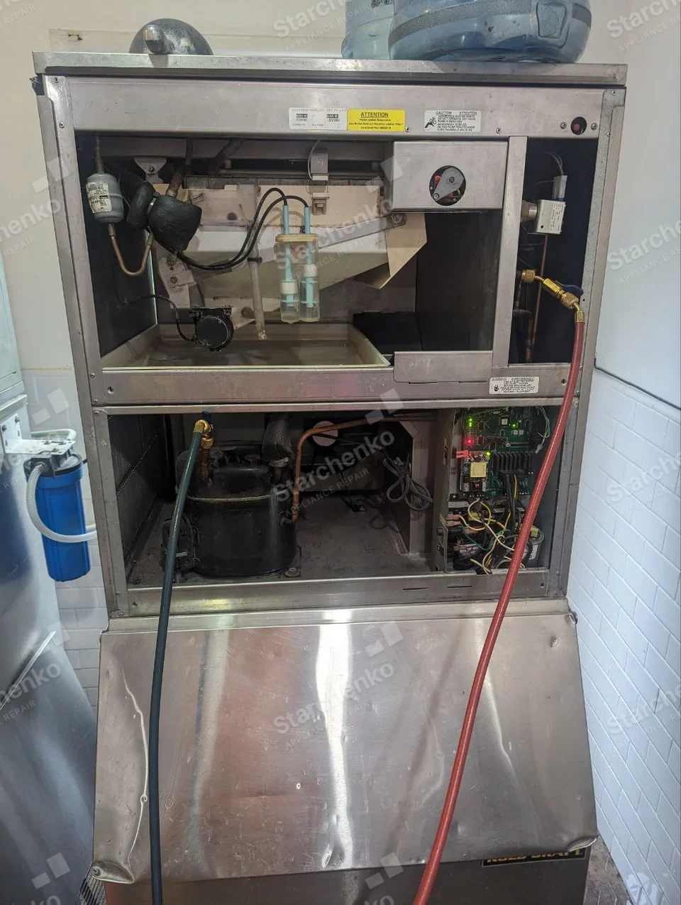 Kold-Draft repair: Commercial ice-making machine opened at upper water circuit, compressor and control board with refrigeration hoses connected.