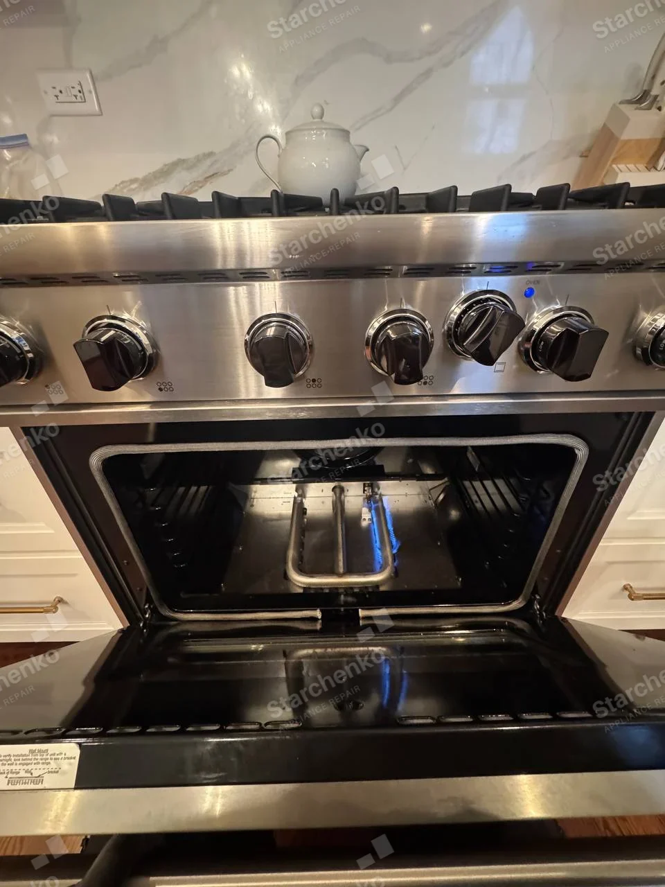 KitchenAid repair: Gas range oven open showing burner flame test.